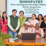Adivasi elders, women, young volunteers and Rajeev Singh at the Hodopathy website inauguration in Giridih on 8 October 2026, connecting traditional knowledge with younger generations.